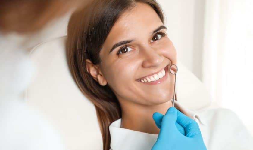 Smiling patient with dental mirror during cosmetic dentistry consultation in Puyallup.
