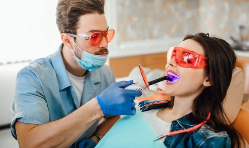 Dentist applying cosmetic dental treatment to patient wearing protective eyewear in Puyallup.