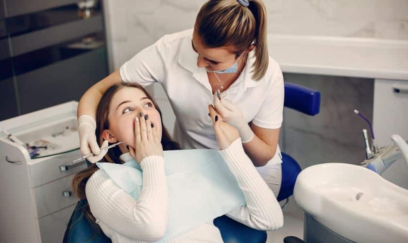 Anxious patient with hand to face receiving emergency dental care from dentist in Puyallup.