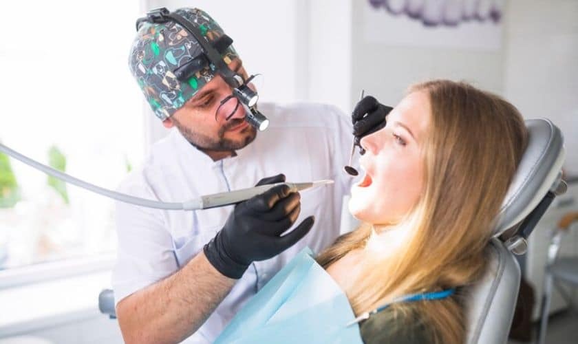 Dentist examining patient's teeth during treatment in modern dental office.