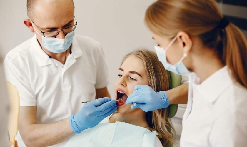Dentist and dental assistant examining patient's teeth during oral examination in Puyallup.