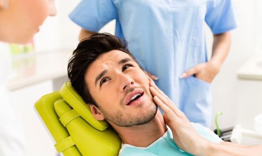 Patient experiencing tooth pain during dental examination with dentist in Puyallup.