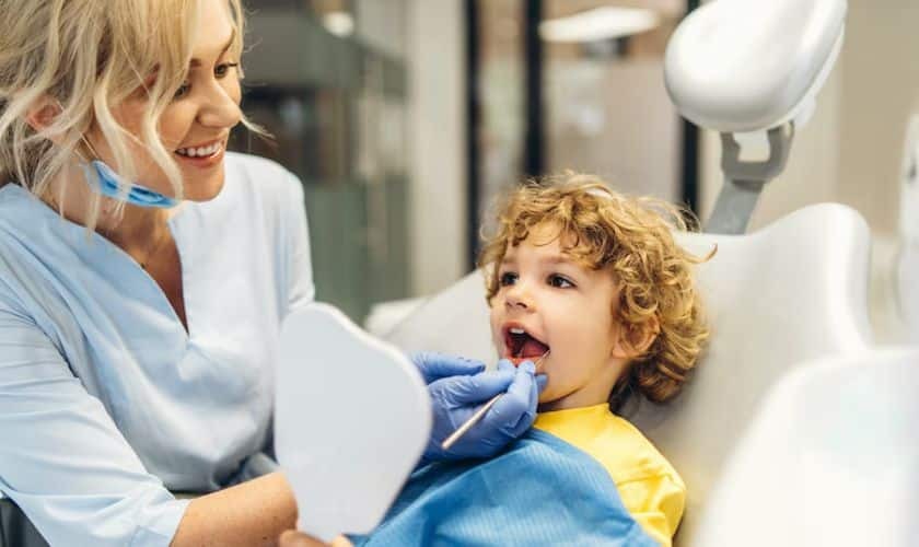 Pediatric dentist examining young child's teeth during dental checkup in Puyallup.