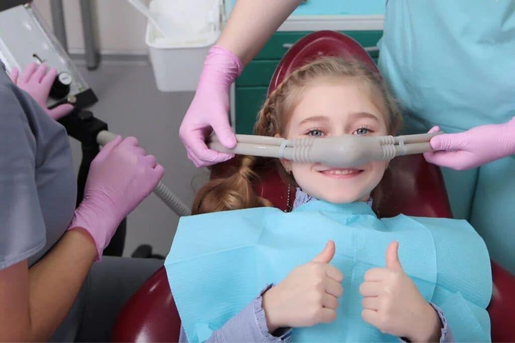 Young patient giving thumbs up during sedation dentistry procedure in Puyallup dental office.