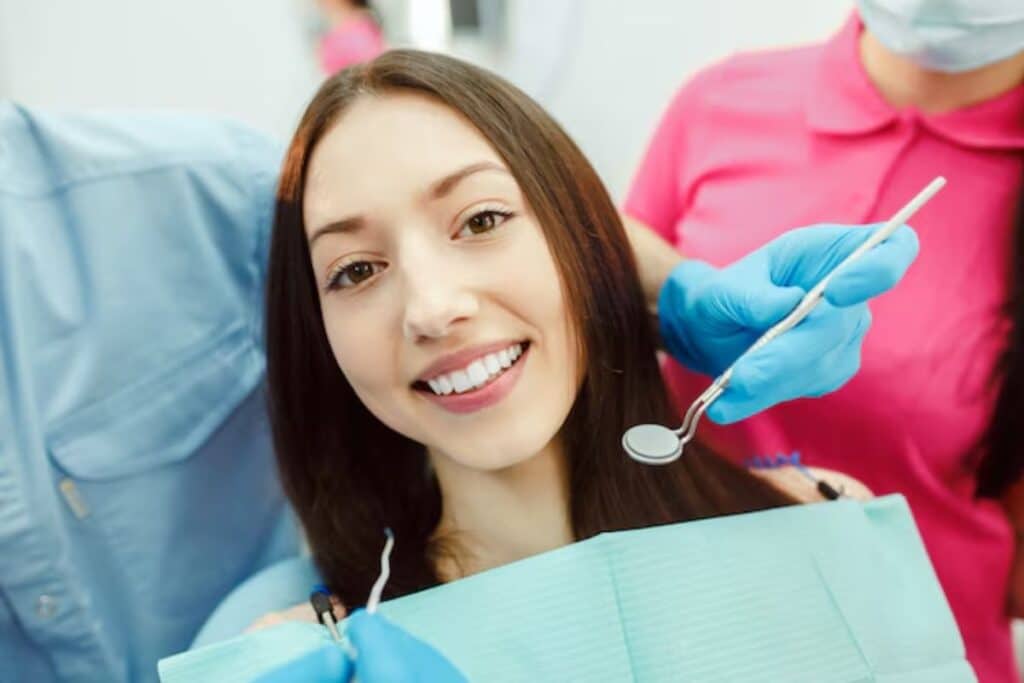 Smiling woman with healthy teeth receiving cosmetic dental examination from dentist in Puyallup.