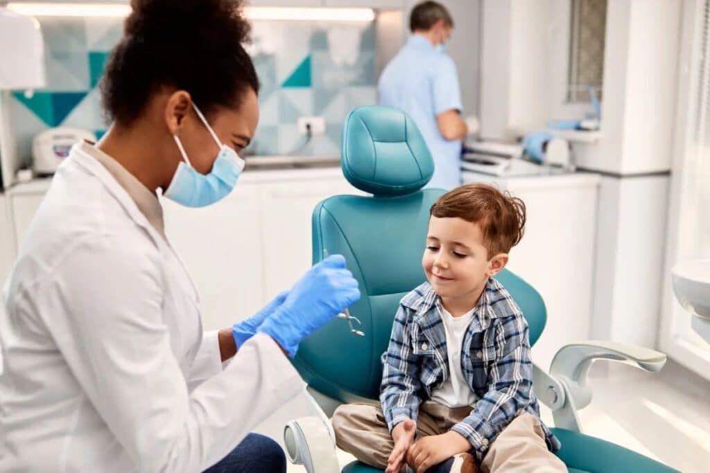 Pediatric dentist examining young boy's teeth in modern dental office in Puyallup.