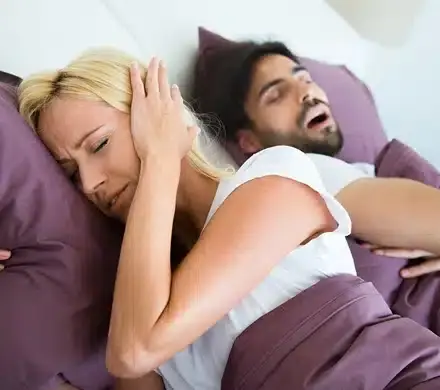 Couple sleeping together in bed, illustrating sleep apnea treatment benefits in Puyallup.
