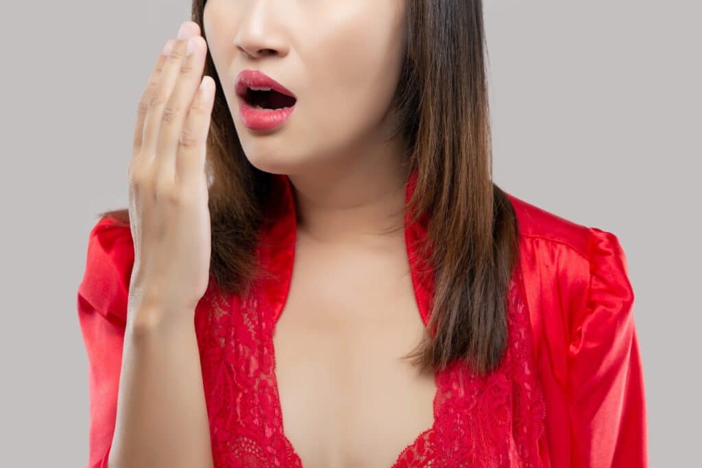 Woman in red demonstrating fresh breath confidence after cosmetic dental treatment.